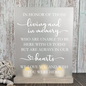May include: White sign with the text "In honor of those living and in memory who are unable to be here with us today but are always in our hearts. We love you and wish you were here."
