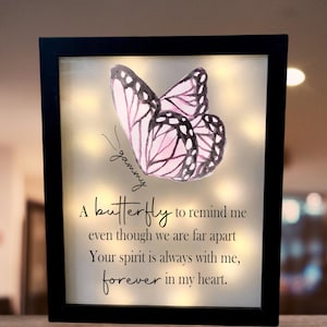 May include: A framed light-up memorial with a pink butterfly and the text "gammy" and "A butterfly to remind me even though we are far apart Your spirit is always with me, forever in my heart."