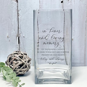 May include: A clear glass vase with the text "in honor and loving memory of those who cannot be here today but are forever present in our hearts today and always" printed on the front.