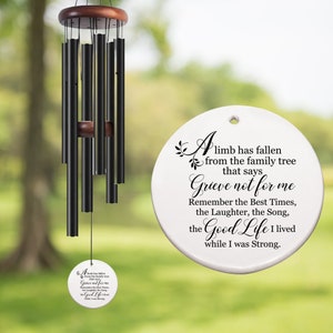 May include: A white ceramic wind chime with a black inscription that reads "A limb has fallen from the family tree that says Grieve not for me Remember the Best Times, the Laughter, the Song, the Good Life I lived while I was Strong."