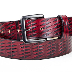 May include: A red leather belt with a geometric pattern and a silver buckle.