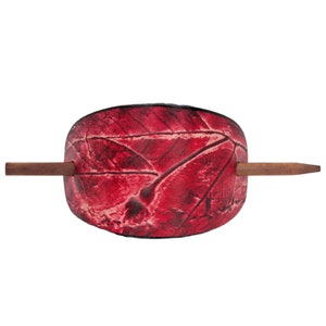 May include: A red leather hair stick with a leaf pattern. The stick has a wooden dowel.