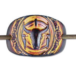 May include: A brown leather hair clip with a bull's head design in yellow, red, and black. The clip has a wooden stick that goes through the center.