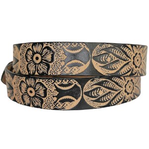May include: A black leather belt with a tan floral design. The belt is folded in half and the design is visible on both sides.