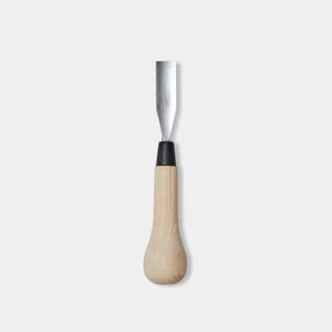 May include: A wood carving chisel. It has a polished steel blade and a light-coloured wooden handle. The handle is teardrop-shaped, with a black ferrule where it meets the blade.