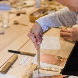 Spoon gouge being used to carve out bowl to spoon on a bench hook.
