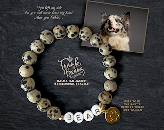 May include: Dalmatian Jasper pet memorial bracelet with gold beads and a paw print charm. The bracelet has the word "BEAR" spelled out in white letters. The text "Keep your fur baby's memory where ever you go" is printed on the black background.