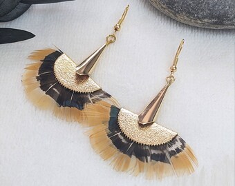 May include: Gold tone earrings with a fan-shaped design made of feathers. The feathers are brown, black, and beige.