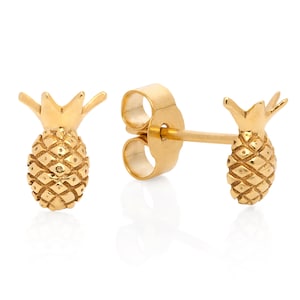 May include: A pair of gold-colored pineapple stud earrings. Each earring features a detailed pineapple design with textured surfaces and a post for pierced ears. The earrings are presented on a white background.