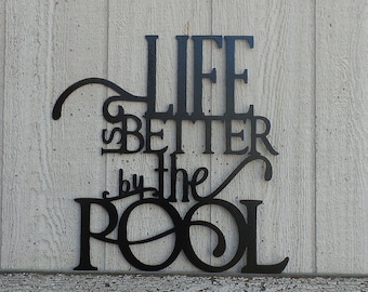 May include: Black metal wall decor with the words "Life is Better by the Pool" in a decorative font.