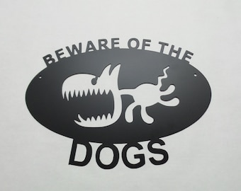 May include: Black metal sign with a white silhouette of a dog with a large mouth and the text "Beware of the Dogs" in white letters.
