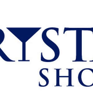 May include: The Crystal Shoppe logo in navy blue. The text is in a serif font, with the word "CRYSTAL" featuring a stylized crystal shape integrated into the letter "Y". The words "THE" and "SHOPPE" are above and below "CRYSTAL".