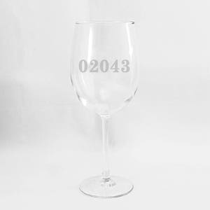May include: A clear glass wine glass with the number 02043 etched on the side.