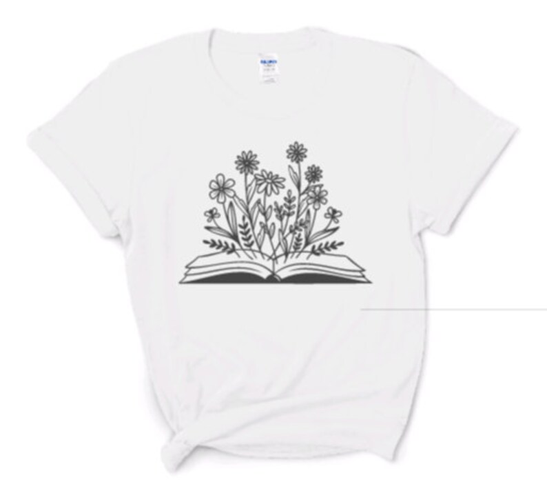 Peut inclure: T-shirt blanc avec une illustration en noir et blanc d'un livre ouvert avec des fleurs qui en sortent.
