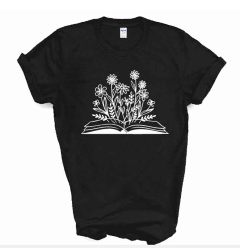 Peut inclure: T-shirt noir avec un motif blanc d'un livre ouvert avec des fleurs qui poussent.