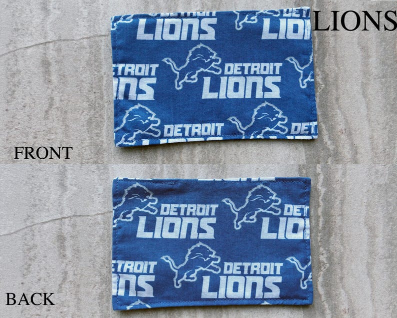 May include: A rectangular fabric patch featuring a repeating pattern of the Detroit Lions logo and text in white on a blue background. The image displays both the front and back sides of the fabric, each labeled with text indicating its orientation.