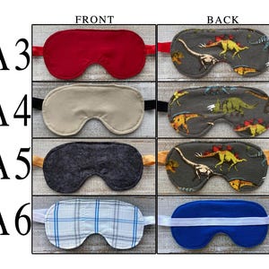 May include: A collection of four sleep masks labeled A3 through A6, showing front and back views. The masks feature various designs including solid red, solid beige, dark gray textured fabric, and a blue and white plaid pattern with elastic straps.