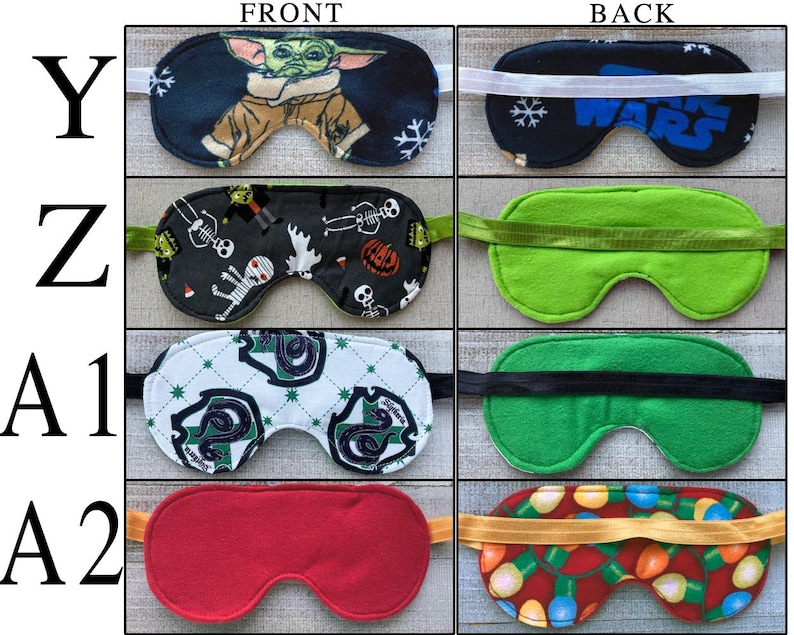 May include: A collection of four sleep masks labeled Y, Z, A1, and A2. Mask Y features a character print and Star Wars text. Mask Z has a Halloween pattern. Mask A1 displays a green snake crest on a white background. Mask A2 is solid red.