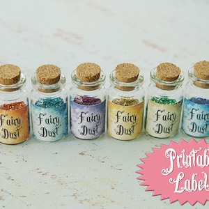 May include: Eight small glass bottles with cork stoppers filled with glitter and labeled "Fairy Dust". The bottles are arranged in a row on a light blue surface. The text "Printable Labels" is written in white on a pink starburst.