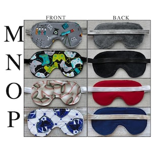 May include: Four sleep masks labeled M, N, O, and P. M features a gray science print with telescopes and formulas. N has a black background with colorful game controllers. O displays a baseball pattern. P shows a blue and white crest design.