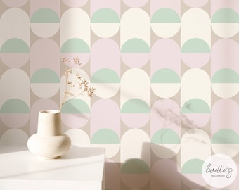 May include: A pastel-colored wallpaper with a repeating pattern of elongated ovals, each bisected by a semi-circle. The color palette includes pink, mint green, and off-white against a neutral beige background. A white vase and dried flowers are in the foreground.