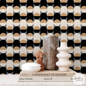 May include: A black, white and beige geometric wallpaper pattern with a half-circle design. The wallpaper is displayed behind a white ceramic bowl, a brown ceramic sculpture and a white ceramic sculpture.