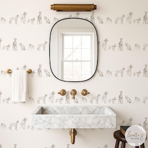 May include: A bathroom with a marble sink, gold fixtures, and a black-framed mirror. The wallpaper features a repeating pattern of dog illustrations in gray. A white towel hangs on a gold towel rack. A dark wooden stool is next to the sink.