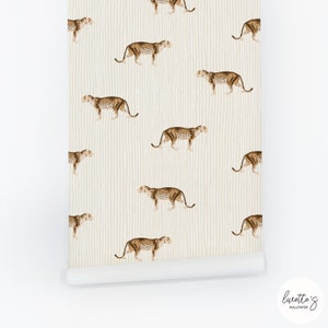Pode incluir: Um rolo de papel de parede com um padrão repetido de leopardos castanhos sobre um fundo creme com riscas verticais. O papel de parede tem um acabamento mate e é adequado para projetos de design de interiores.