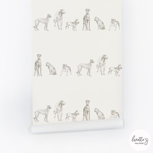 May include: Off-white wallpaper roll featuring a repeating pattern of various dog breeds in a sketched style. The dogs are depicted in shades of gray, creating a neutral and versatile design suitable for any room. The wallpaper is from the brand, Luvette's Wallpaper.