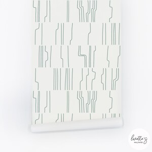 May include: A roll of white wallpaper with a repeating pattern of thin, light green lines. The lines are arranged in a geometric pattern, creating a modern and minimalist look. The wallpaper is rolled up and ready to be hung.