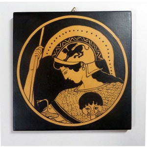 May include: Square wall art featuring a classical Greek warrior in a helmet with a winged creature, rendered in black and tan. The artwork is set against a black background, with a circular design and a decorative border.