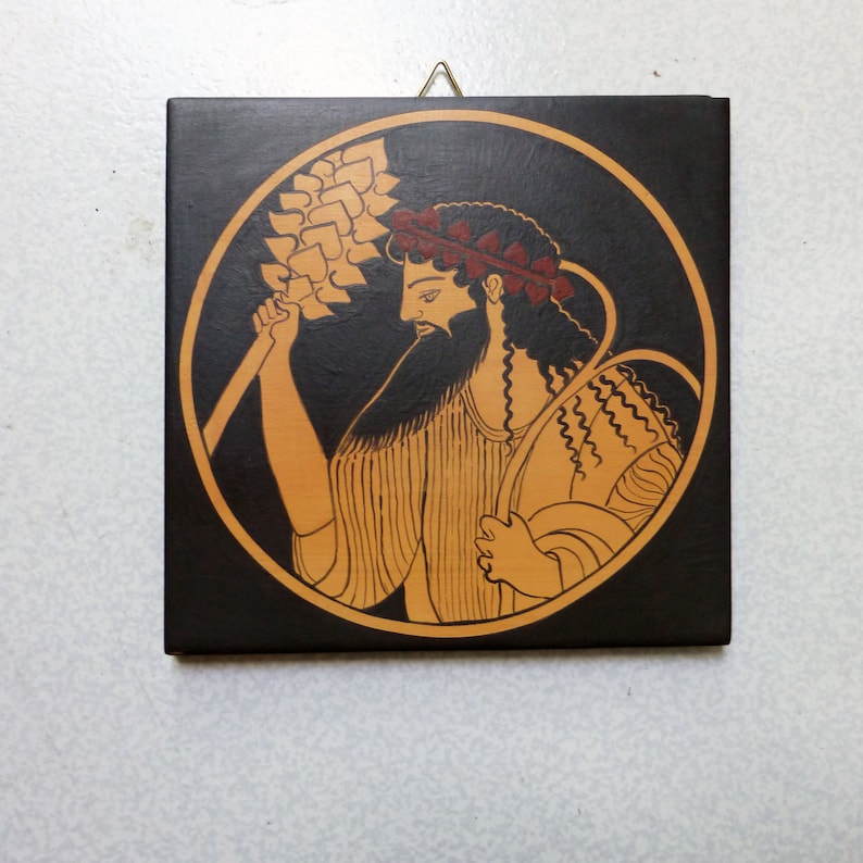 May include: Square wooden plaque with a classical Greek illustration. It shows a bearded figure holding a wheat stalk, within a circular frame. The color scheme includes black, tan, and red accents, with a gold-coloured border.