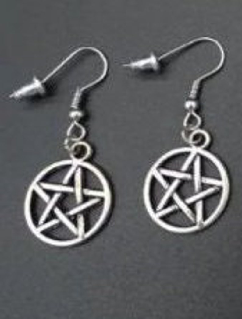 May include: A pair of silver earrings with a pentagram design. The earrings are made of metal and have a simple, minimalist style.