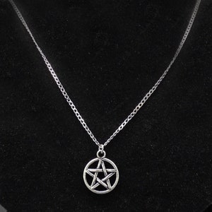 May include: A silver chain necklace with a silver pentagram pendant.