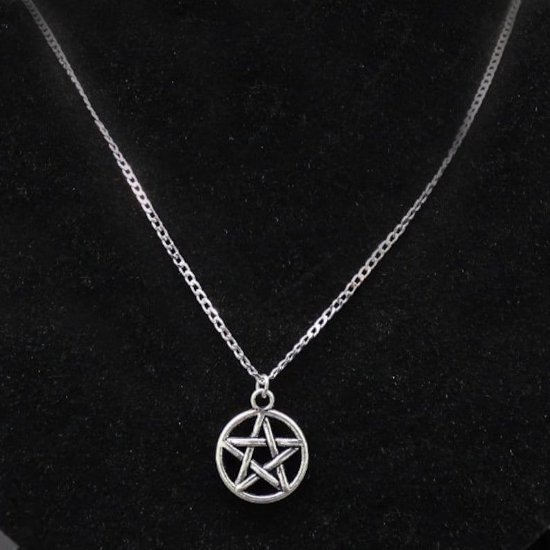 May include: A silver chain necklace with a silver pentagram pendant.