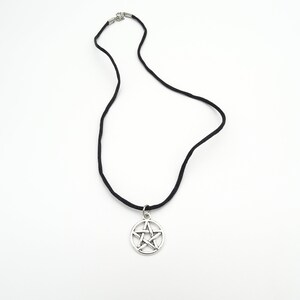 May include: A black cord necklace with a silver pentagram pendant.