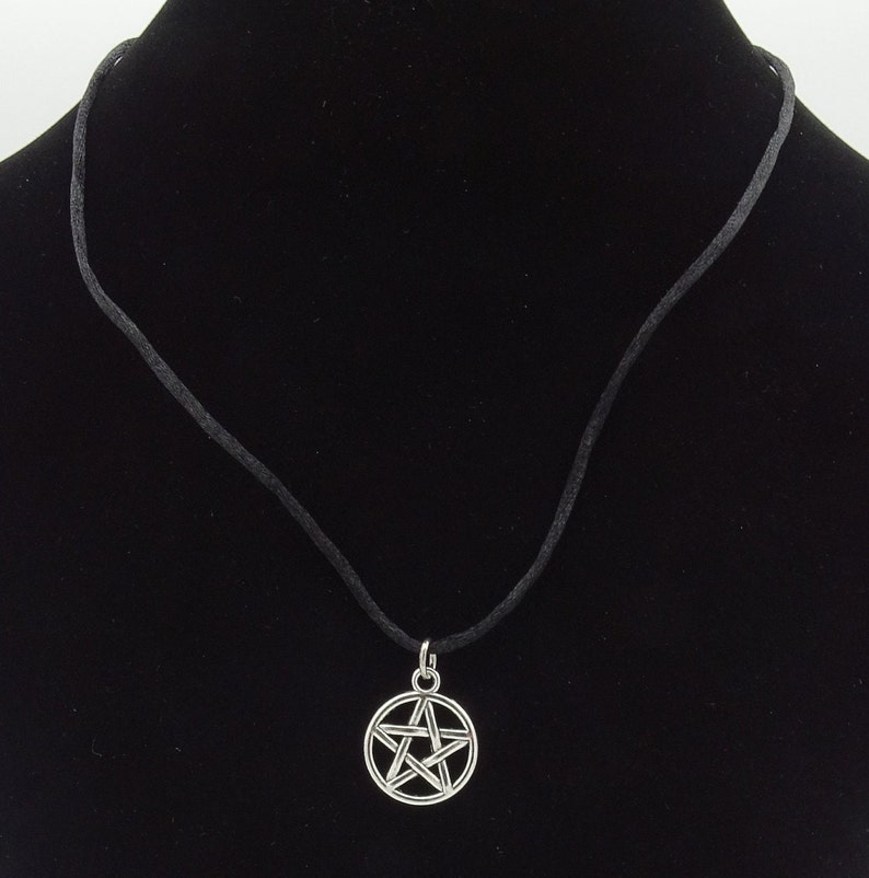 May include: A black cord necklace with a silver pentagram pendant.