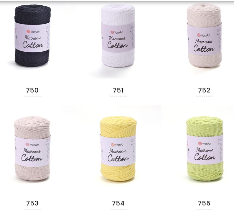 May include: A collection of six spools of YarnArt Macrame Cotton yarn in various colors. The colors include navy, white, beige, light beige, yellow, and light green. Each spool has a label with the brand name and product type.