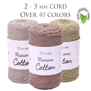 May include: Three spools of YarnArt Macrame Cotton cord in beige, brown, and olive green. The label reads "2-3 mm cord, over 40 colours" and "Eco-friendly yarn."