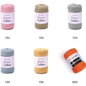 May include: A collection of six spools of YarnArt Macrame Cotton yarn in various colors. The colors include pink, olive green, gray, blue, yellow, and orange. Each spool has a label with the brand name and product details.