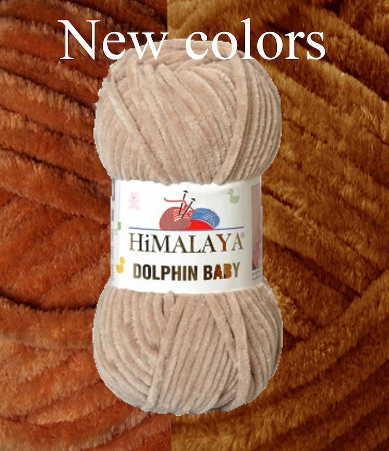 May include: A ball of Himalaya Dolphin Baby yarn in a light brown color. The yarn is soft and plush, with a velvety texture. The label reads "New colors" and features the brand name and product details.