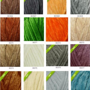 May include: A collection of yarn skeins in various colors, including brown, gray, orange, green, and teal. Each skein has a soft, velvety texture and is labeled with a product number and a "NEW" sticker. Ideal for knitting and crochet projects.