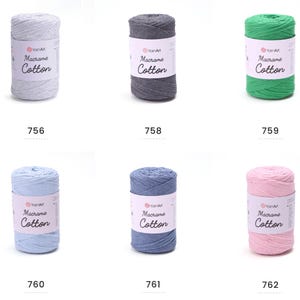 May include: Six spools of YarnArt Macrame Cotton yarn in various colors: light gray, dark gray, green, light blue, blue, and pink. Each spool has a label with the brand name and product details. The numbers 756, 758, 759, 760, 761, and 762 are printed below each spool.