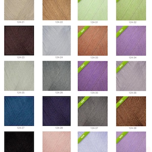 Op de afbeelding: Een kleurenkaart met garen in verschillende tinten, waaronder beige, bruin, blauw, paars en groen. Elke garenkleur is voorzien van een nummer. Sommige strengen hebben een "NIEUW" sticker.