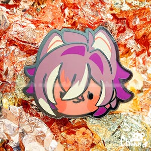 Può includere: Spilla in smalto in stile cartone animato raffigurante un personaggio con capelli rosa, viso color pesca e contorno argentato. La spilla è ambientata su uno sfondo di lamina d'oro e rame.