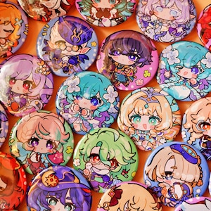 Może przedstawiać: Kolekcja okrągłych przypinek z kolorowymi ilustracjami postaci w stylu anime. Każda przypinka przedstawia unikalną figurkę w stylu chibi z żywymi włosami, wyrazistymi oczami i szczegółowymi strojami w różnych odcieniach niebieskiego, różu i zieleni.