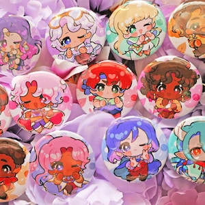 Może przedstawiać: Kolekcja dwunastu okrągłych przypinek z kolorowymi ilustracjami postaci w stylu chibi. Każda przypinka przedstawia unikalną animowaną postać z różnymi kolorami włosów, strojami i wyrazami twarzy, ułożone w układzie siatki.