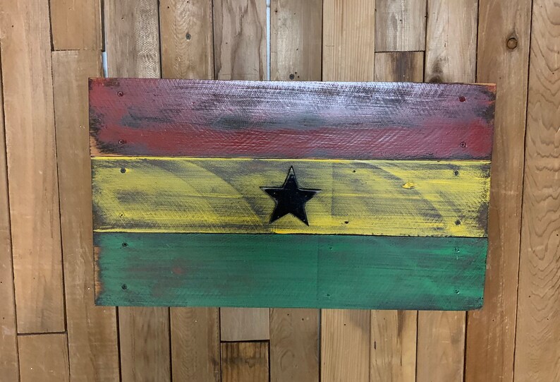 May include: A wooden sign painted with the colors of the Ghanaian flag. The flag is red, yellow, and green with a black star in the center.