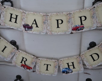 May include: A vintage car themed Happy Birthday banner with each letter on a separate card. The cards are decorated with a map-like pattern and feature small vintage cars.