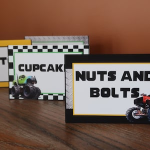 May include: Four monster truck themed food labels with black and yellow borders. The labels read "Pit Stop", "Cupcakes", and "Nuts and Bolts". Each label features a monster truck graphic.